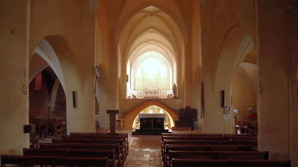 Main nave of the Basilica of Saint Fris in Bassoues, France, with soaring Romanesque arches, altar, and soft natural light. Photo © John Reps, Cornell University Library, CC BY 4.0
