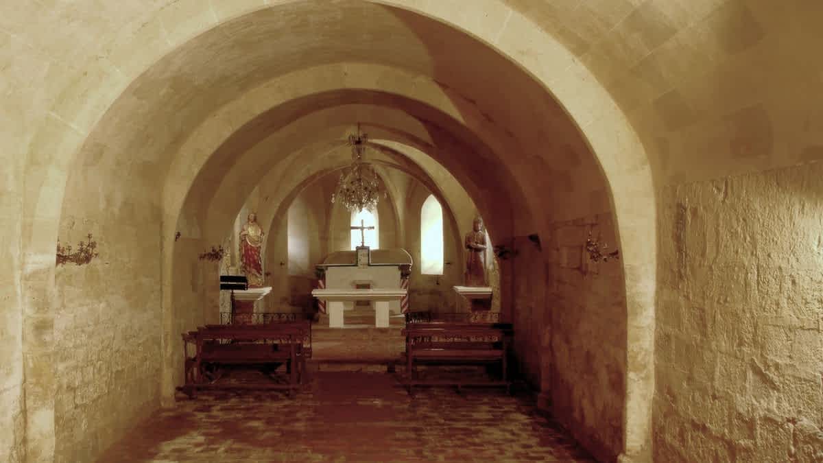 Crypt of the Basilica of Saint Fris in Bassoues, France, with stone vaulted ceiling, altar, and statues of saints. Photo © John Reps, Cornell University Library, CC BY 4.0
